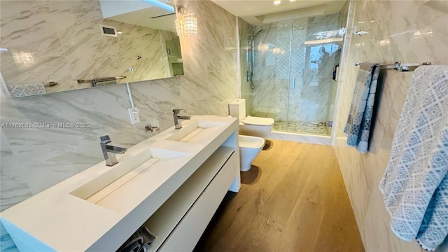 full bath with a marble finish shower, toilet, a bidet, tile walls, and a sink