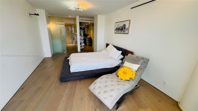 bedroom with wood finished floors and a closet