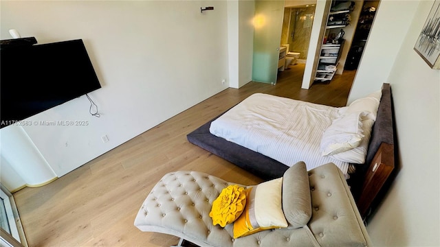 bedroom featuring connected bathroom and wood finished floors