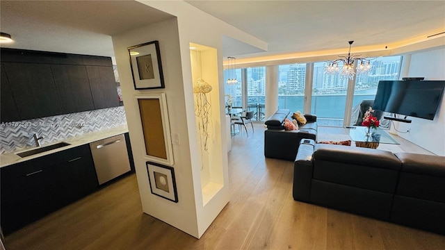 living room featuring a chandelier, light wood-style flooring, and expansive windows