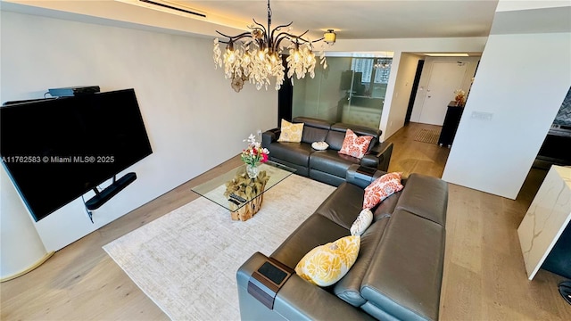 living room with an inviting chandelier, wood finished floors, and a wall mounted air conditioner