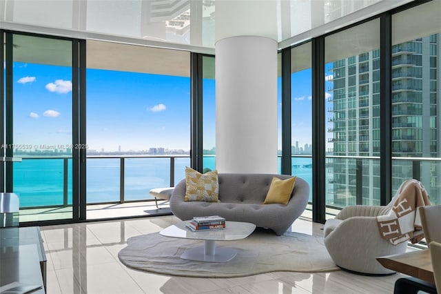 living area featuring expansive windows, a water view, and a city view