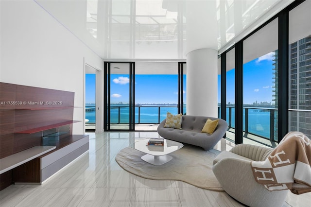 living room with expansive windows, a water view, and a healthy amount of sunlight