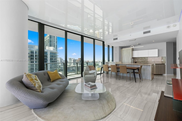 living room with a city view, floor to ceiling windows, and visible vents