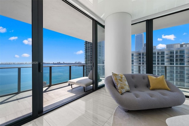 living room featuring a wall of windows and a water view