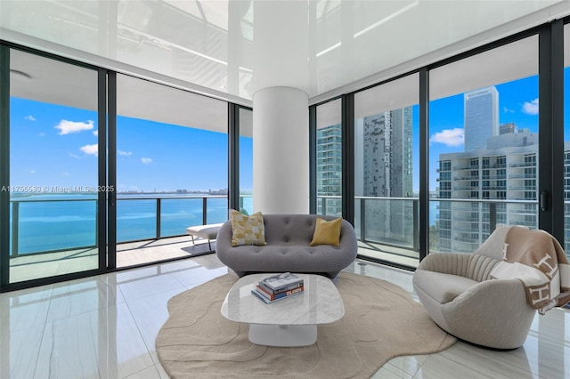 living area featuring tile patterned floors, a city view, floor to ceiling windows, and a water view