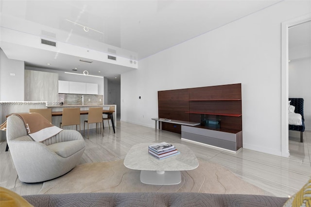 living room with visible vents, baseboards, and a towering ceiling