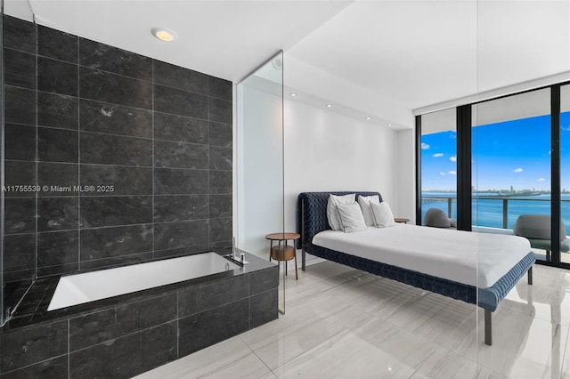 bedroom with a wall of windows, a water view, tile walls, and recessed lighting