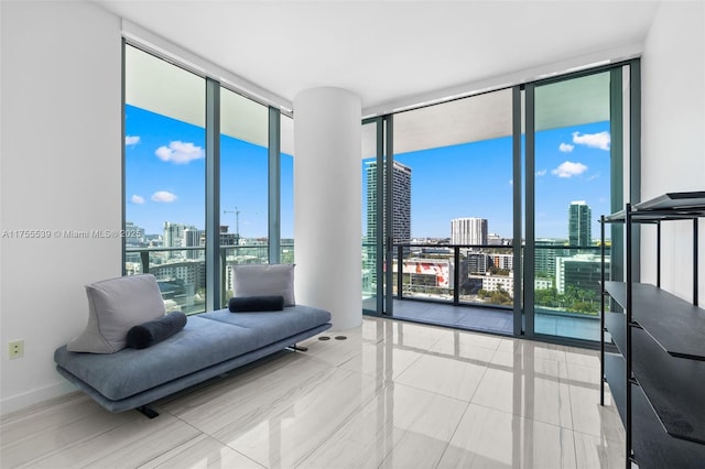 living area with baseboards, a city view, and floor to ceiling windows