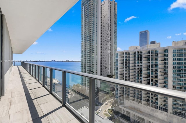 balcony featuring a water view and a city view