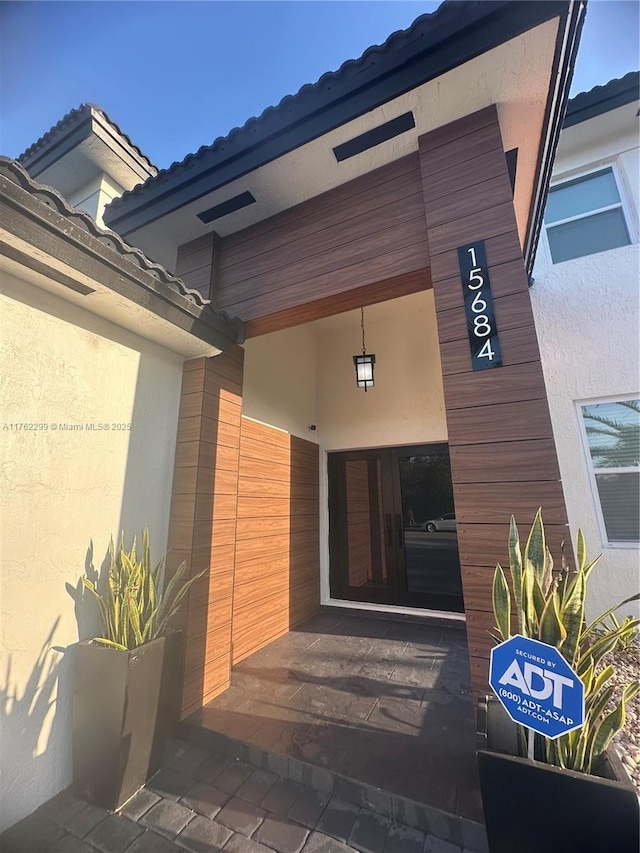 doorway to property featuring stucco siding