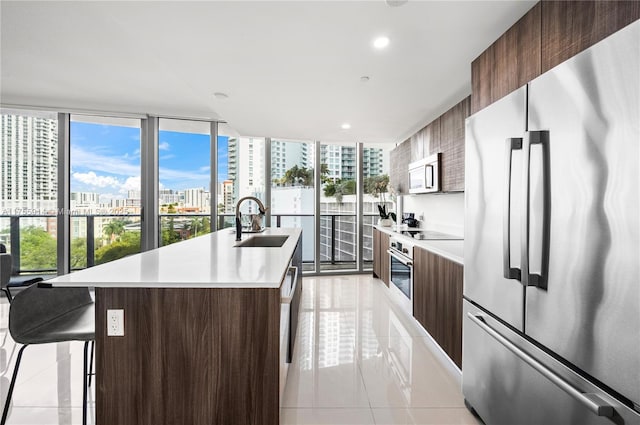 kitchen featuring modern cabinets, a city view, a sink, stainless steel appliances, and light countertops