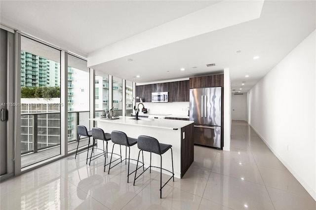 488 NE 18th St Unit 917, Miami, FL 33132 - kitchen with stainless steel appliances, modern cabinets, a kitchen bar, a wall of windows, and light countertops
