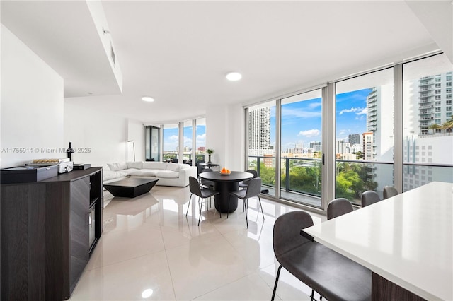 dining space with light tile patterned flooring, a city view, and expansive windows