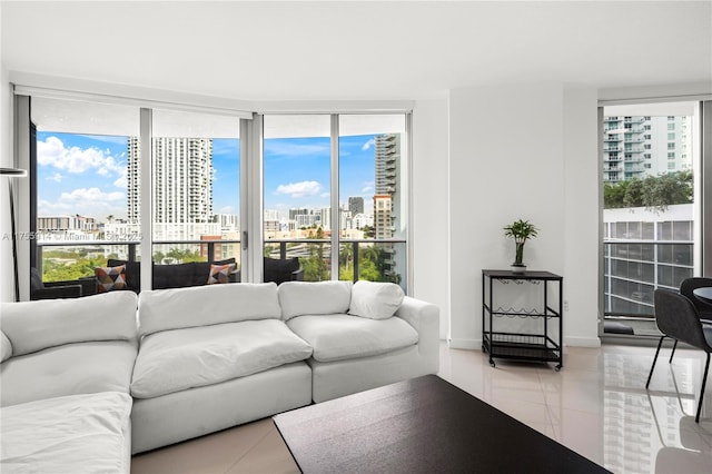 living area with light tile patterned floors, baseboards, a view of city, and plenty of natural light