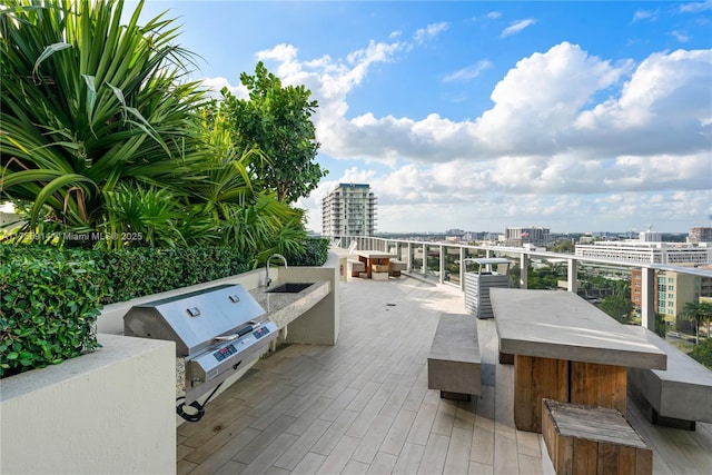 view of patio / terrace with a view of city, area for grilling, and a sink