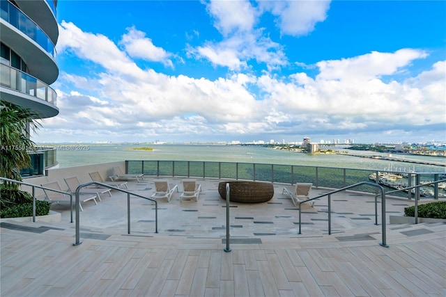 wooden terrace featuring a patio area and a water view