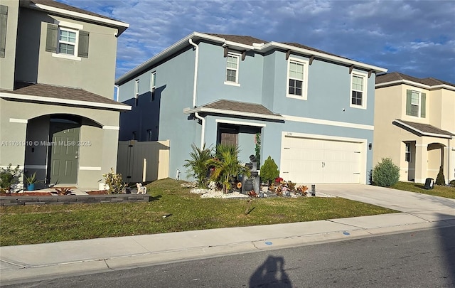 view of front of home featuring stucco siding, an attached garage, driveway, and a front lawn