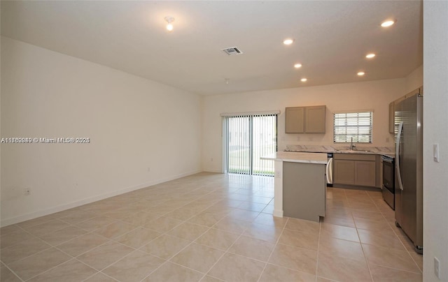 kitchen featuring visible vents, light countertops, light tile patterned floors, gray cabinets, and stainless steel appliances