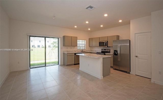 kitchen with a center island, light tile patterned floors, recessed lighting, gray cabinets, and stainless steel appliances