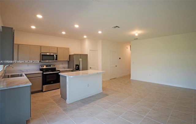 kitchen featuring visible vents, a kitchen island, recessed lighting, appliances with stainless steel finishes, and a sink