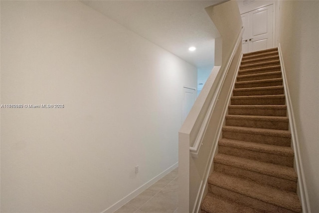 stairway featuring tile patterned flooring, recessed lighting, and baseboards