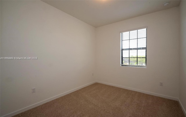 unfurnished room with carpet flooring and baseboards