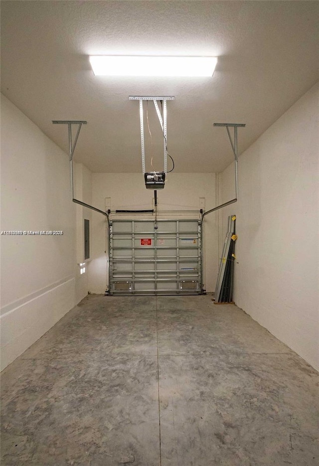 garage featuring electric panel and a garage door opener