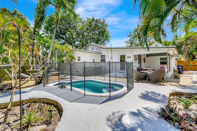 view of swimming pool featuring a patio, fence, and a fenced in pool