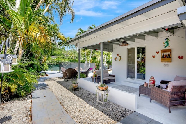 view of patio featuring ceiling fan, outdoor lounge area, and fence