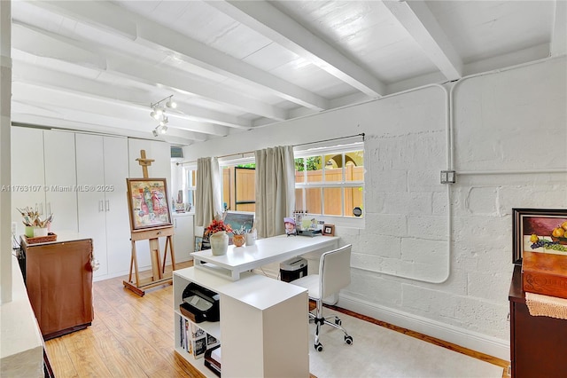 office space with beamed ceiling, concrete block wall, light wood-style floors, and baseboards