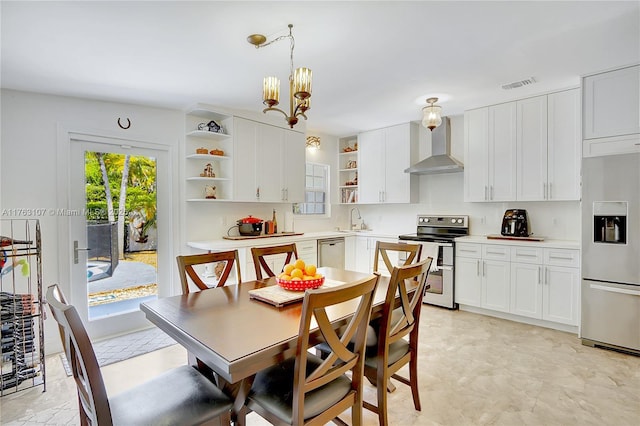 kitchen featuring visible vents, appliances with stainless steel finishes, white cabinets, wall chimney exhaust hood, and open shelves