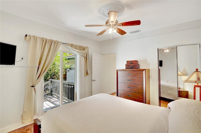 bedroom with visible vents, access to exterior, wood finished floors, baseboards, and ceiling fan