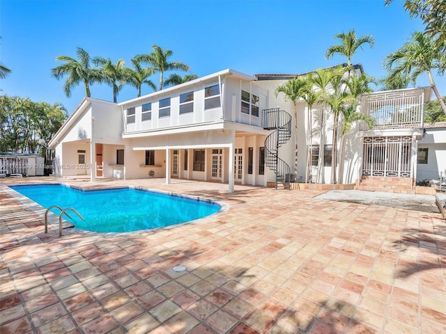 outdoor pool with a patio and stairway