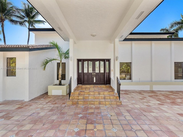 property entrance featuring french doors and stucco siding