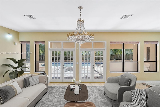 living room featuring french doors, an inviting chandelier, and visible vents