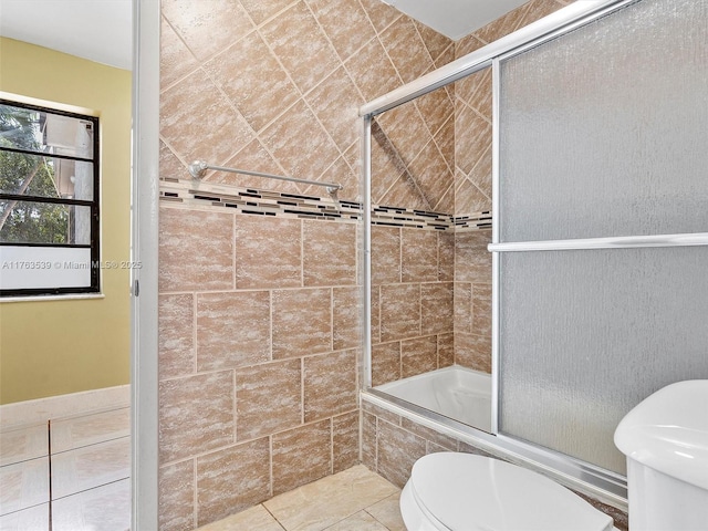 full bathroom featuring tile patterned floors, toilet, and tiled shower / bath