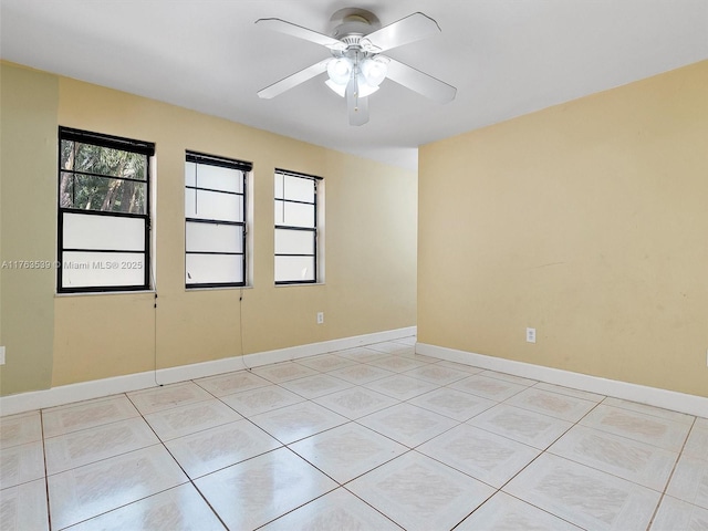 spare room featuring baseboards and a ceiling fan