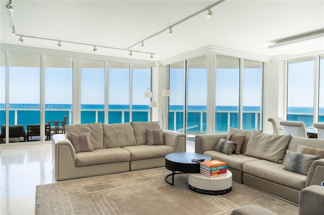 living room with rail lighting, a wall of windows, and a water view