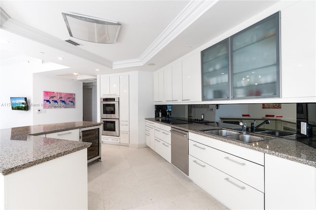 kitchen with visible vents, beverage cooler, ornamental molding, stainless steel appliances, and a raised ceiling