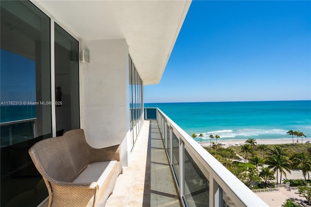 balcony featuring a beach view and a water view