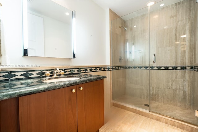 full bathroom with a stall shower and vanity