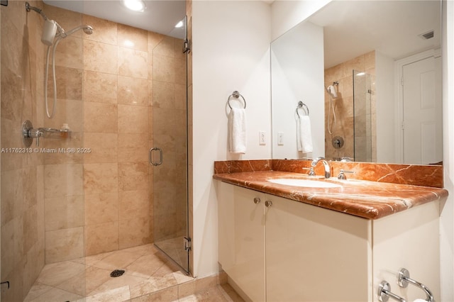 bathroom with visible vents, a stall shower, and vanity