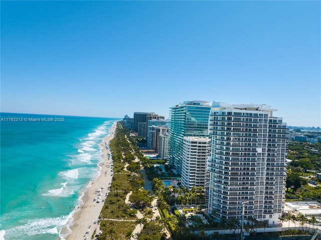 drone / aerial view with a water view, a city view, and a beach view