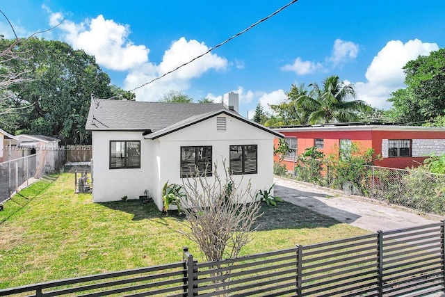 view of front facade with a front yard, fence private yard, and stucco siding