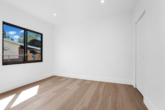 unfurnished room with recessed lighting, wood finished floors, and baseboards