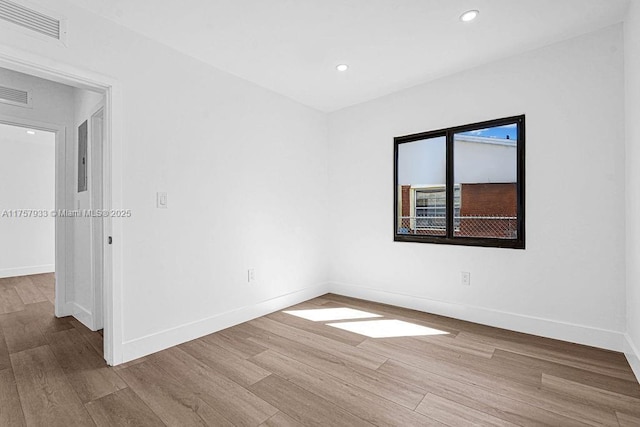 spare room with recessed lighting, visible vents, baseboards, and wood finished floors