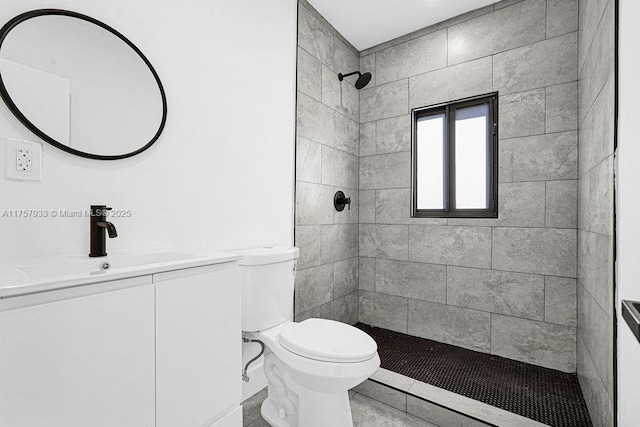 bathroom with tiled shower, toilet, and vanity