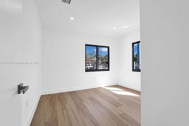 spare room with visible vents, recessed lighting, wood finished floors, and baseboards