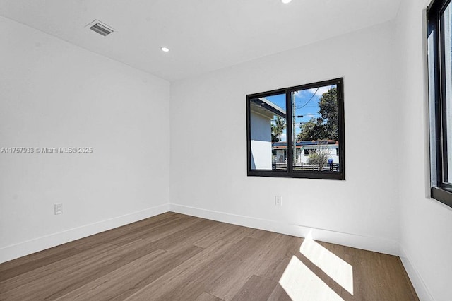 spare room featuring recessed lighting, visible vents, baseboards, and wood finished floors